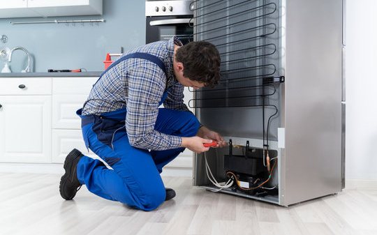 Engineer connecting a fridge freezer