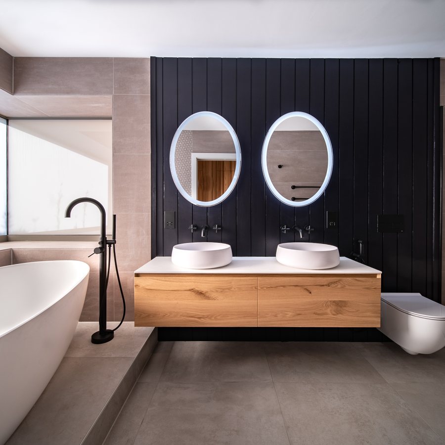 Freestanding bath and twin basin vanity with black panelling