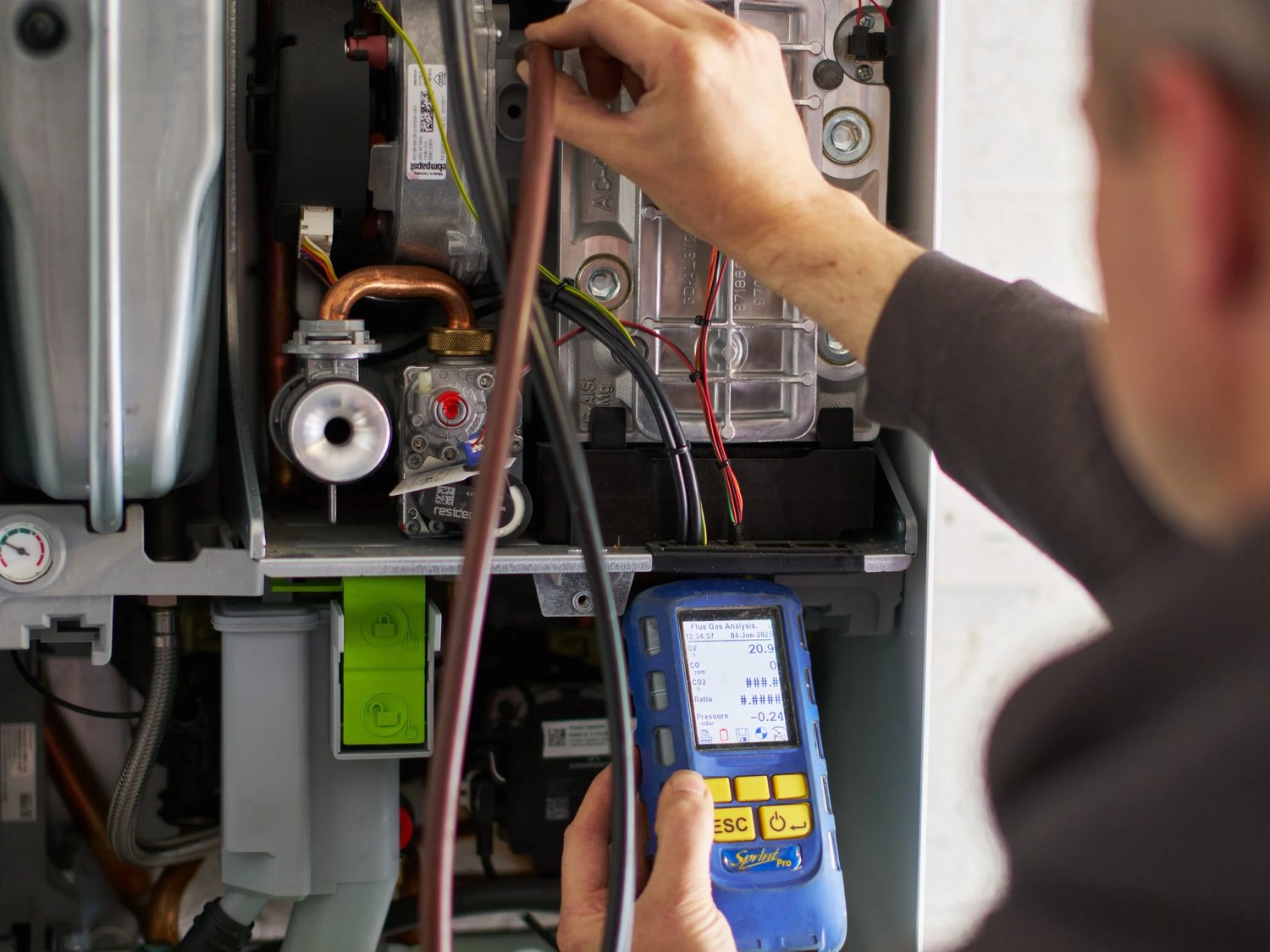 Gas Safe engineer taking flue gas analyser readings on an open boiler during an annual service
