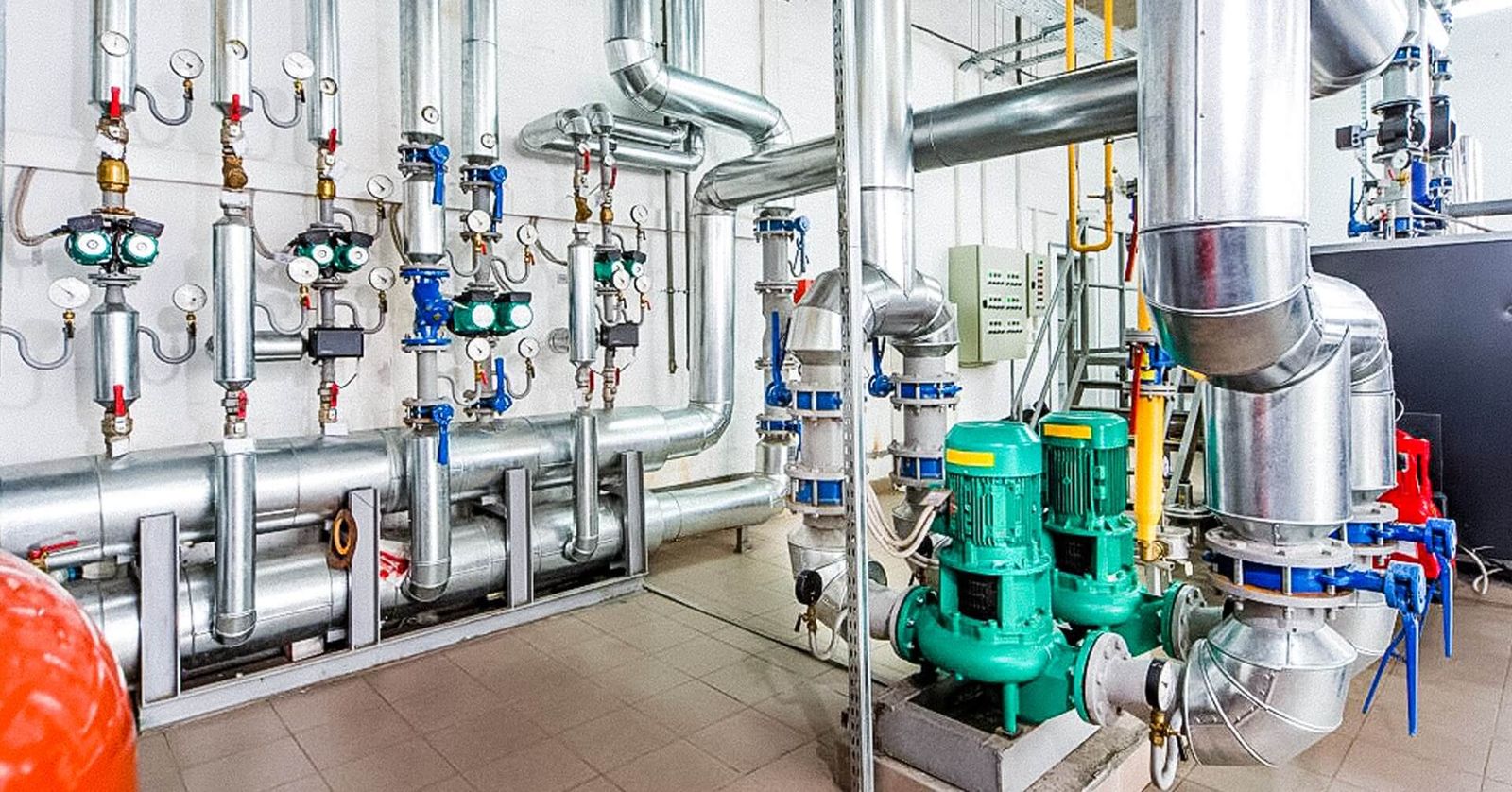 Commercial boiler room with pumps, valves and pressure gauges