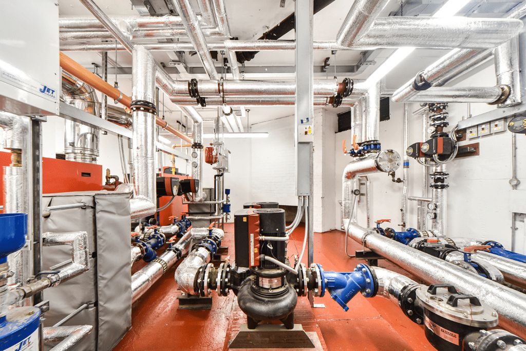 Commercial plant room with pumps and insulated heating pipework