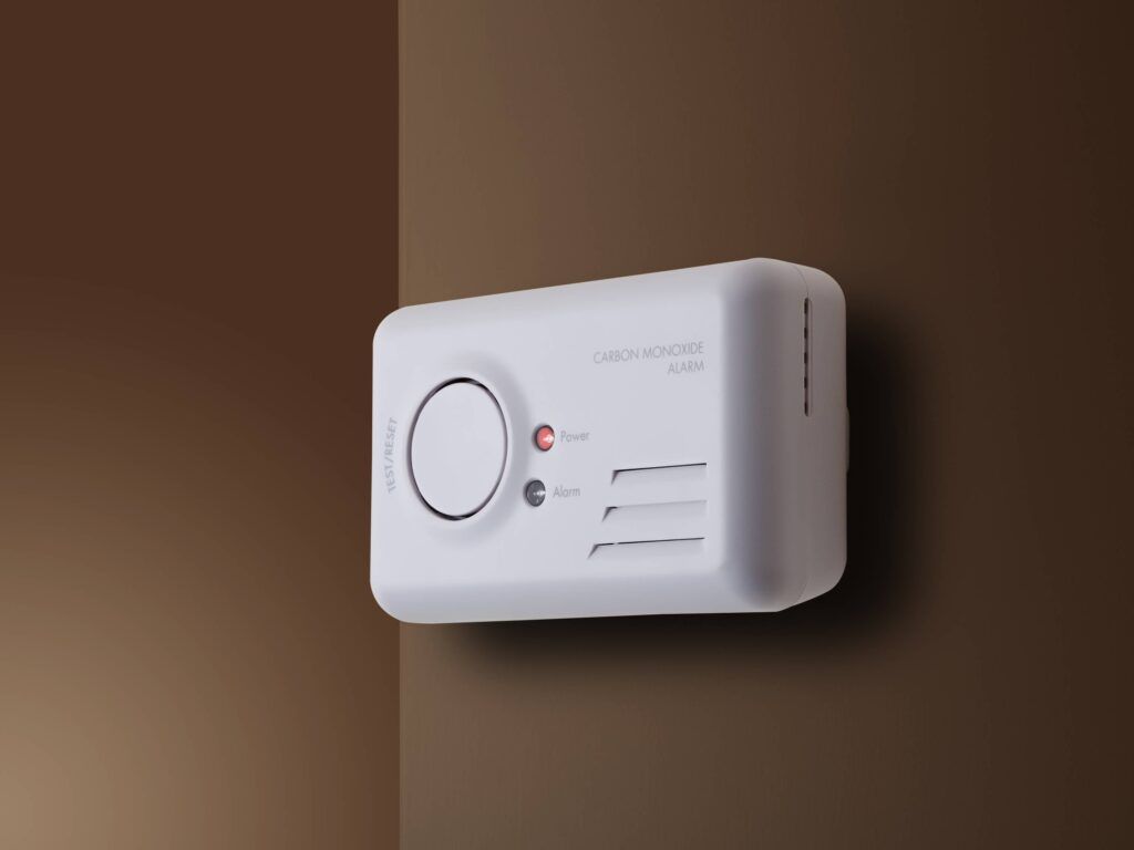 White carbon monoxide alarm mounted on a wall