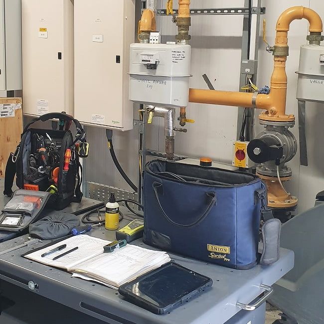 Commercial gas meter room with test equipment and paperwork