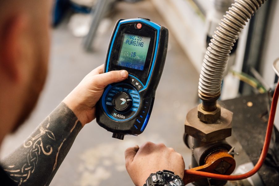 Engineer holding a digital gas meter showing the purging reading