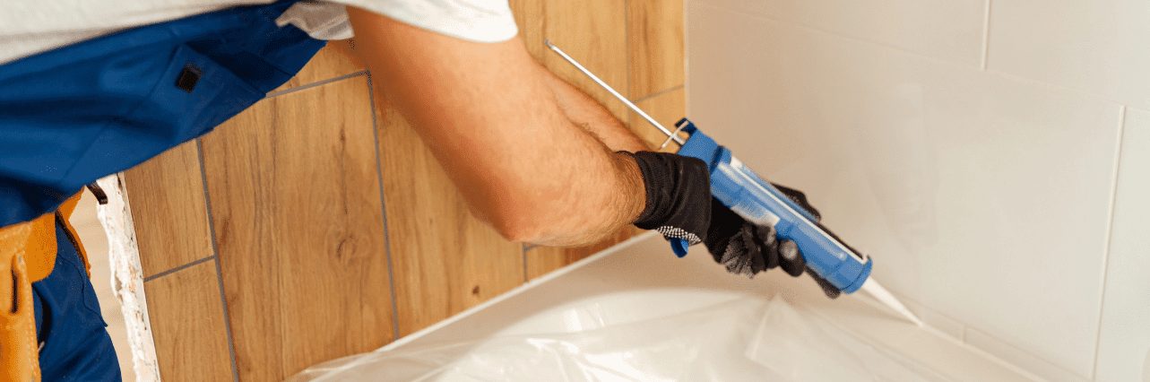 Silicone sealant being applied along a bath edge