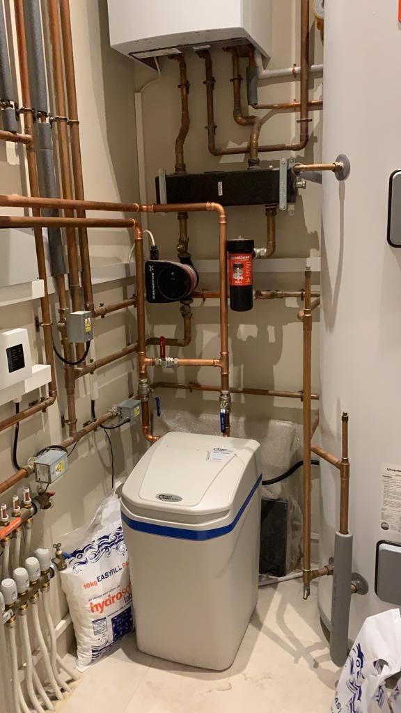 Water softener installed in a plant room beside the heating pipework