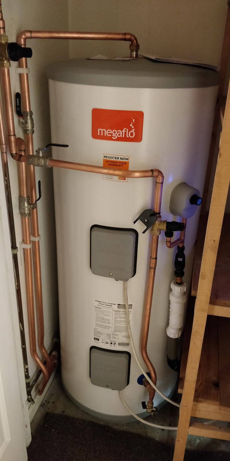 Megaflo Eco unvented cylinder in an airing cupboard with its safety group and tundish