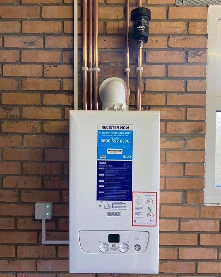 Baxi 800 combi installed on an exposed brick wall, with an ADEY MagnaClean filter fitted on the return and the pipework run neatly in copper.