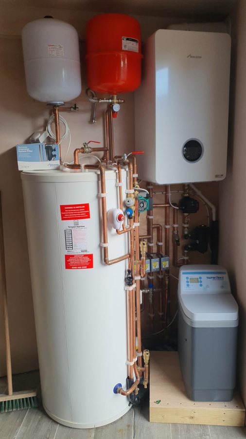 Worcester system boiler with an unvented cylinder, both expansion vessels and a water softener, all inside one utility cupboard.
